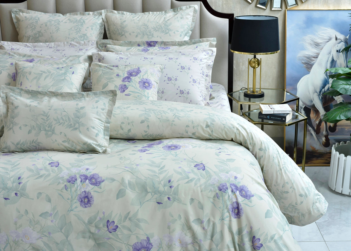 Quilted eurosham cover set with cloud blue base and purple floral design on bed