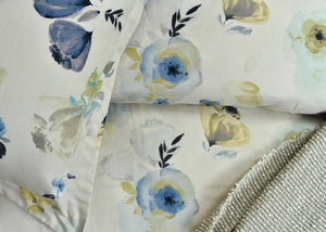 Cotton quilt cover close-up: pale background with blue flowers, yellow accents, and textured border