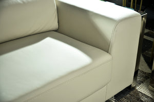 Cream upholstered sofa arm and seat cushion with stitched edges