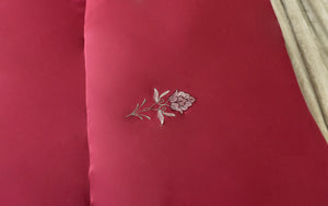 Red comforter fabric with white floral embroidery