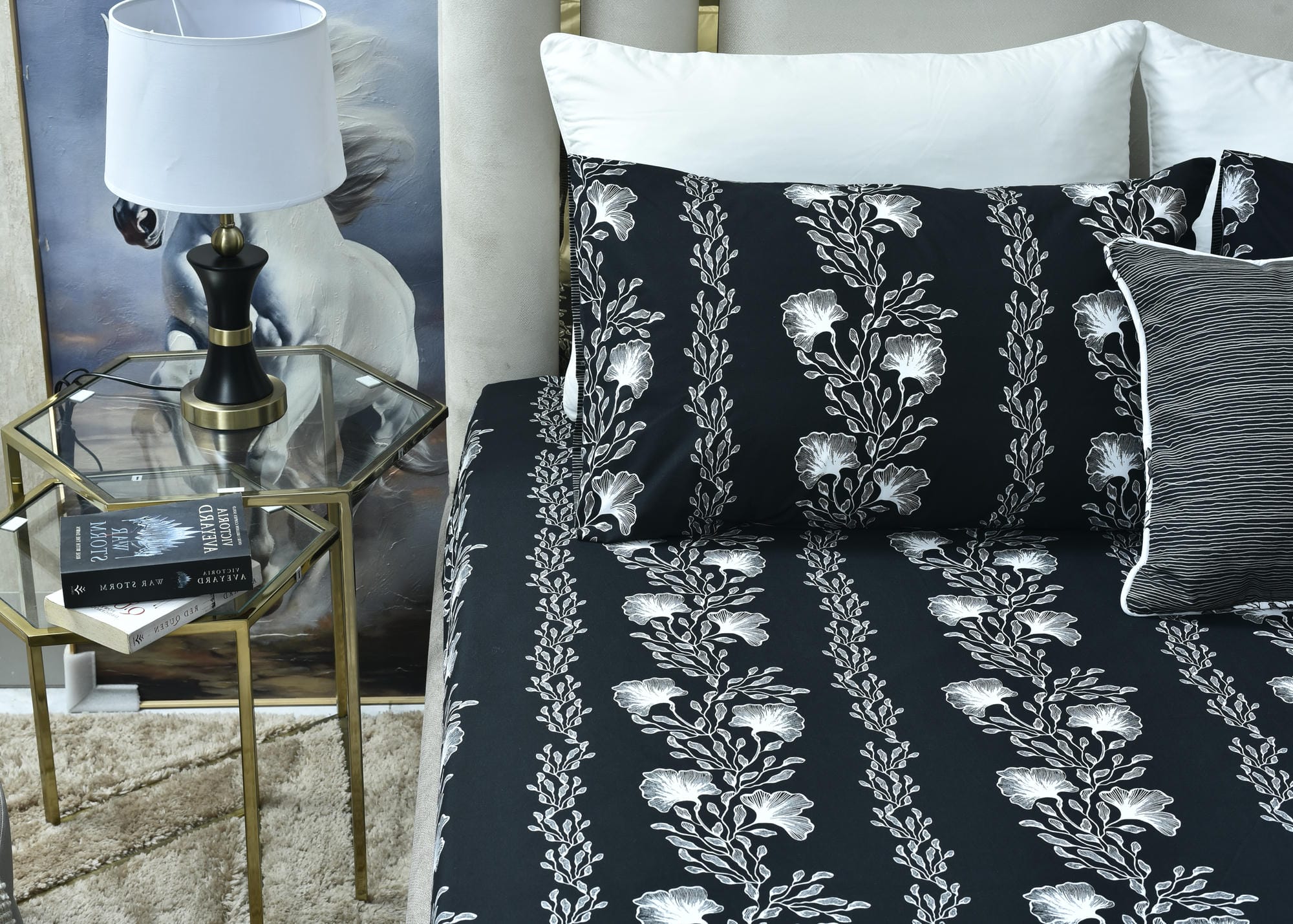 Dark navy bed sheet with white floral vines, shown folded over the mattress.