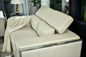 Cream chaise sofa with reclined backrest, rounded arm cushion, and throw blanket