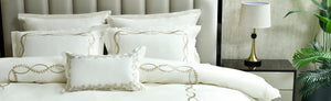 White 7-piece duvet cover set with gold embroidered loop trim and matching pillows