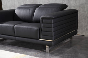 Black sofa corner with armrest panel stitching and visible metal base supports