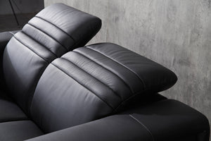 Close-up of black sofa armrest and back cushions with smooth padded panel stitching