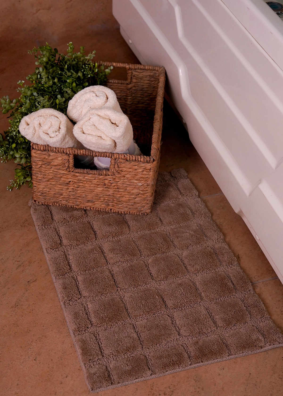 Brown bath mat featuring raised square textured blocks