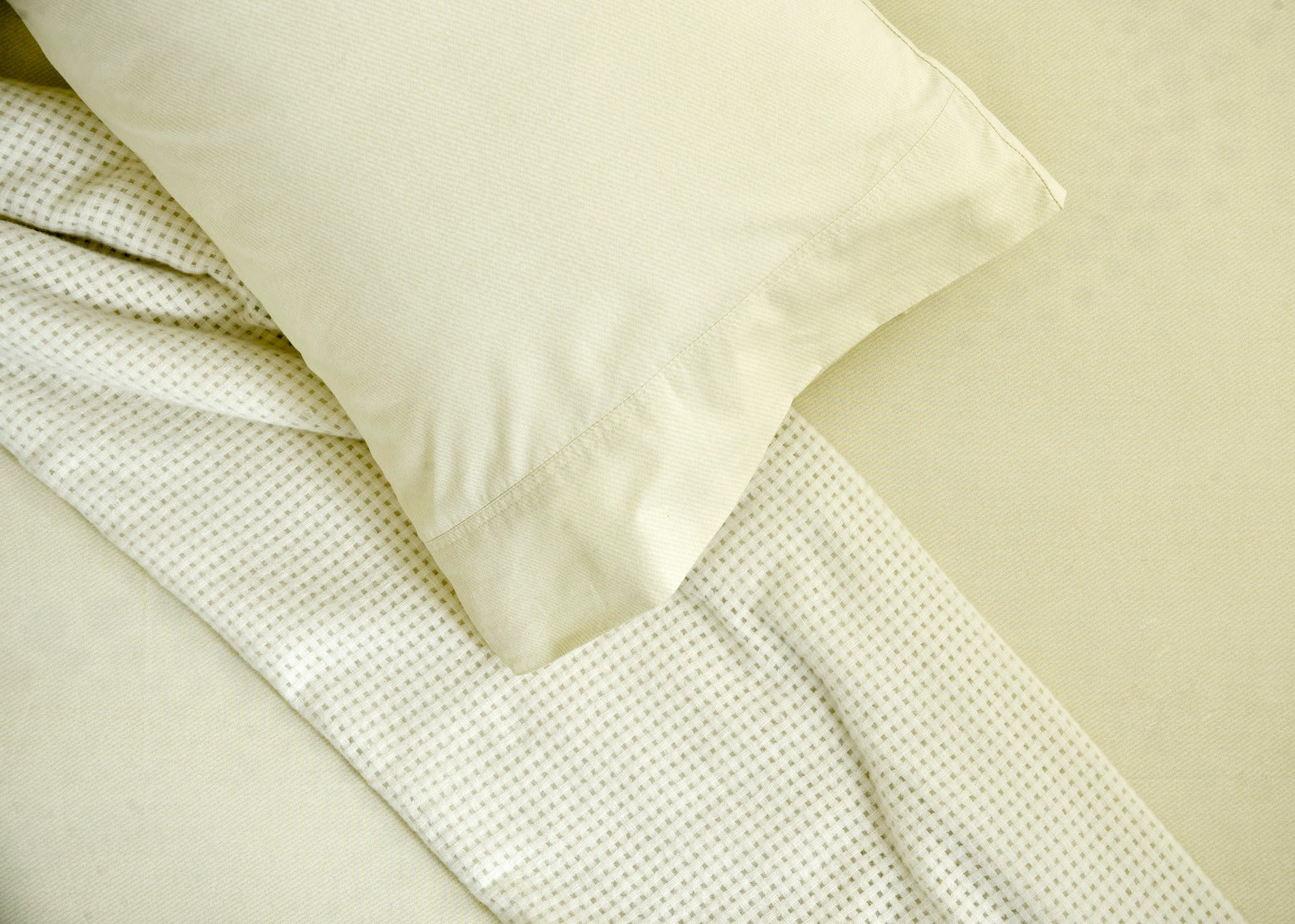 Ivory cotton sateen bed sheet corner with stitched edge and folded hem