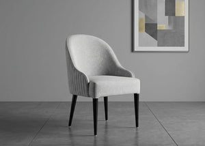 Upholstered dining chair with curved back and dark tapered legs