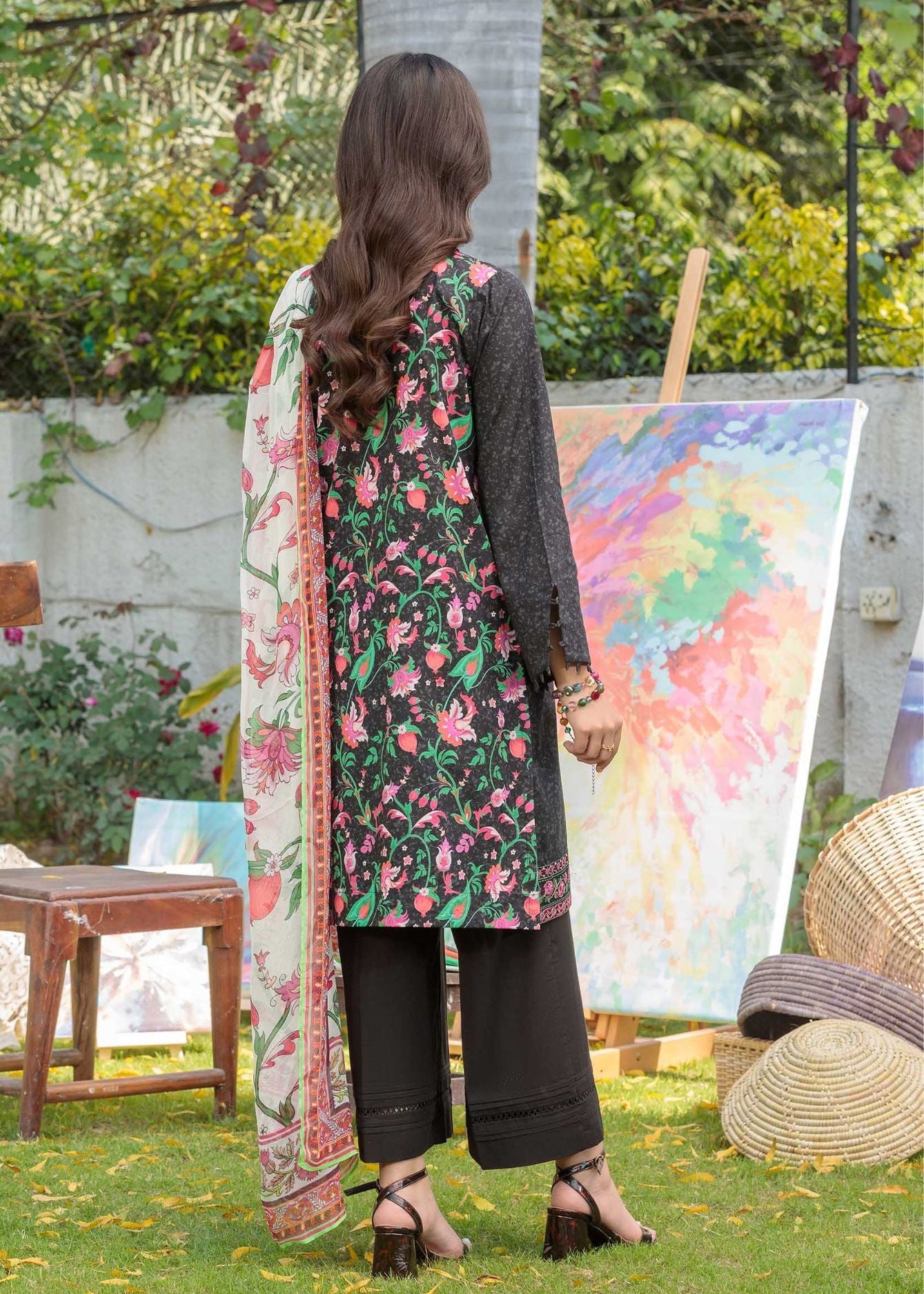 Women's 3-piece suit back view: dark kurta with floral print dupatta and black pants.