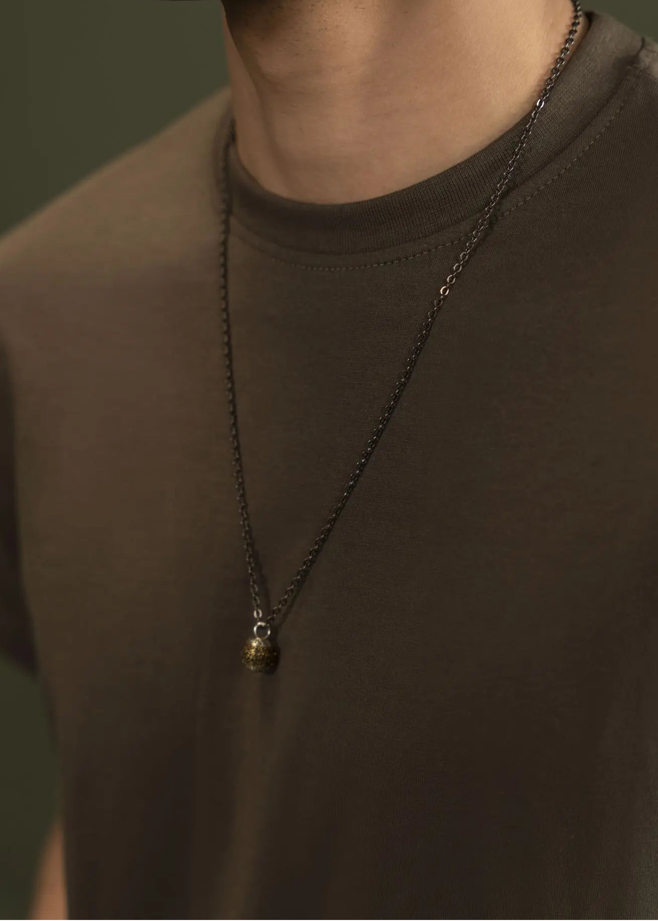Men's olive T-shirt with crew neck and short sleeves, close-up at neckline