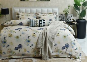 Cotton quilt cover in pale tones with blue and yellow floral print and textured throw