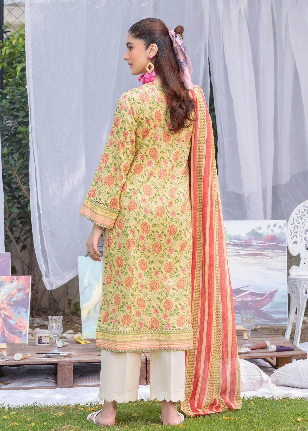 Yellow floral long kurta suit with tie neck and embroidered trim; white pants; striped dupatta