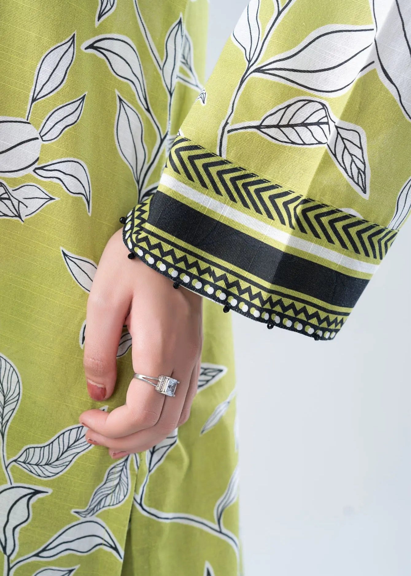 Lime green printed sleeve with black-and-olive striped cuff and pom trim, co-ord set