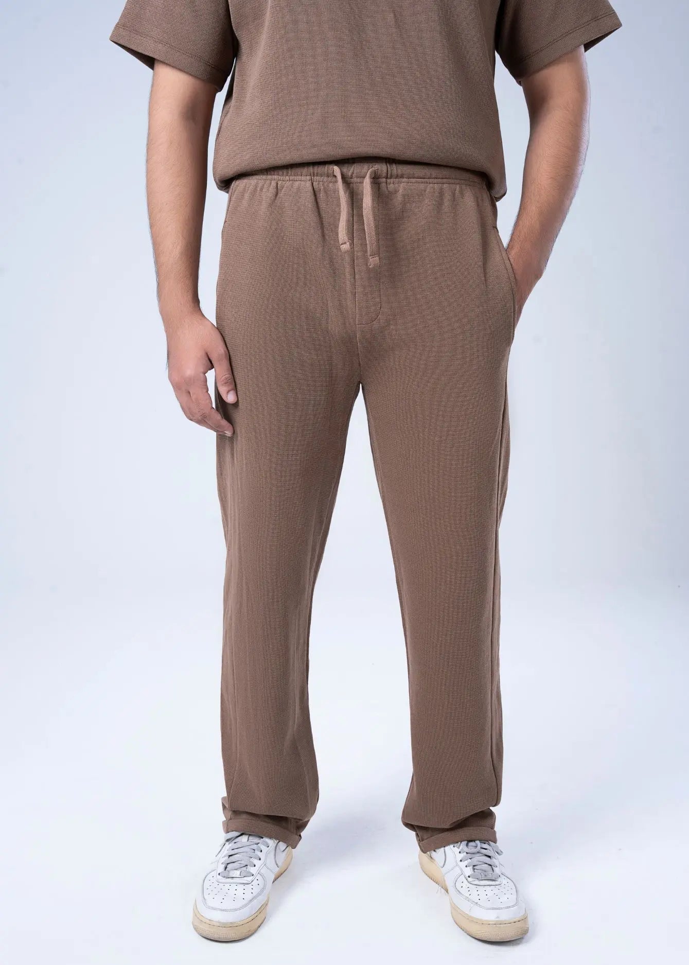 Men's brown waffle knit pull-on trousers with drawstring waist and straight legs.
