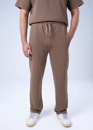 Men's brown waffle knit pull-on trousers with drawstring waist and straight legs.