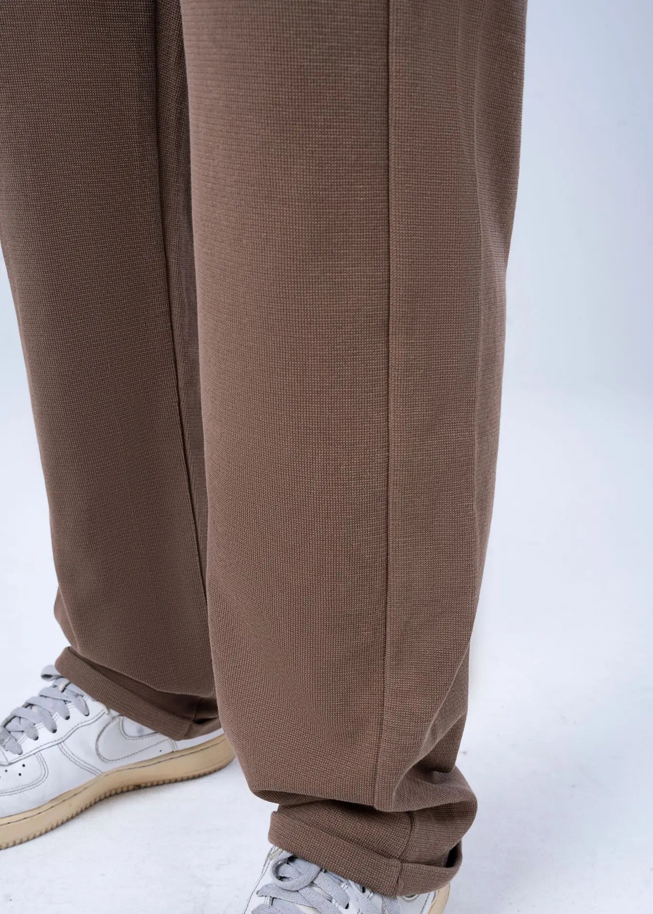 Men's brown pull-on trouser legs with relaxed hem and elasticated ankle cuff.