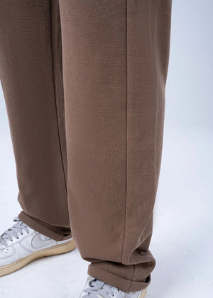 Men's brown pull-on trouser legs with relaxed hem and elasticated ankle cuff.
