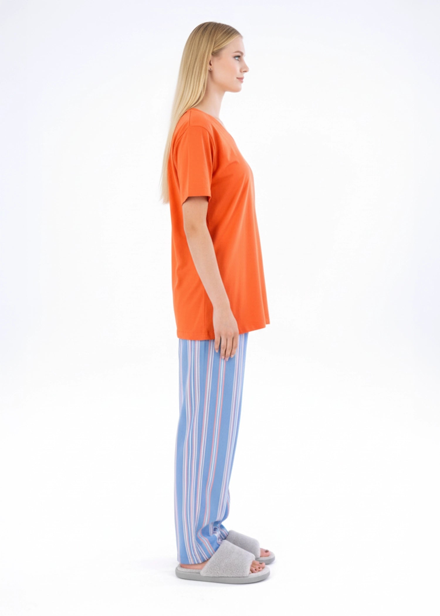 Women’s night suit with orange V-neck top and blue striped pajama pants, side view