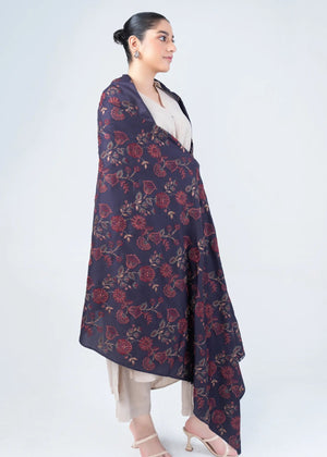 Women's wool winter shawl in dark navy with burgundy floral pattern, worn over beige outfit