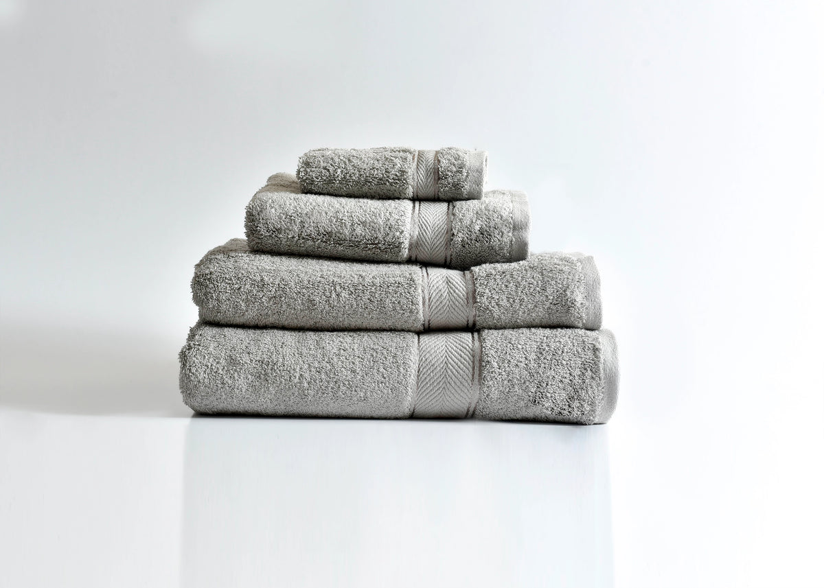 Pima cotton bath towel stack, light gray with folded edges and rolled towels