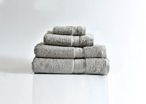 Pima cotton bath towel stack, light gray with folded edges and rolled towels