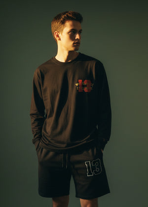 Men's charcoal black long-sleeve crewneck T-shirt with chest graphic logo, 3/4 view