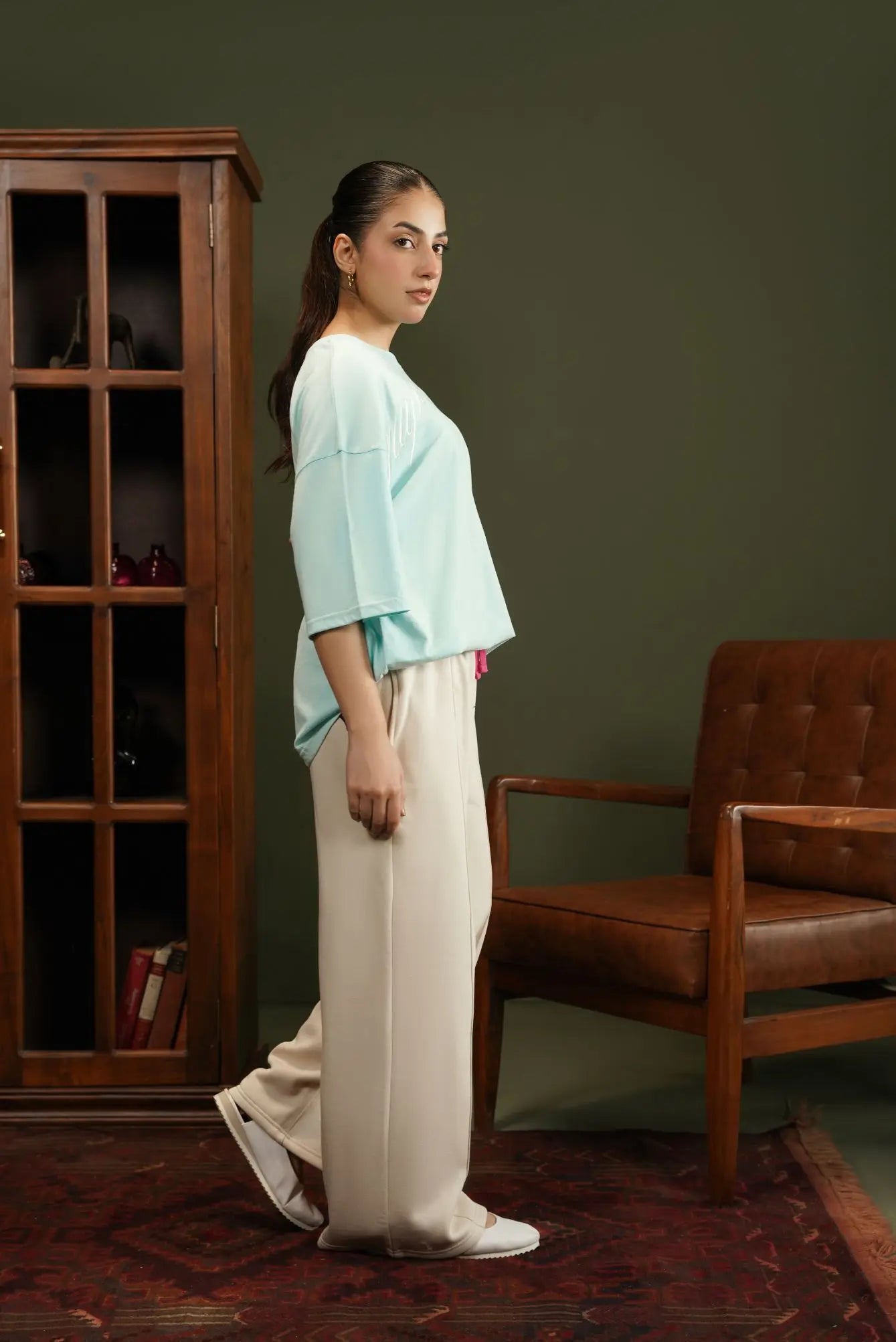 Light blue knitted crew-neck top with short sleeves, side view