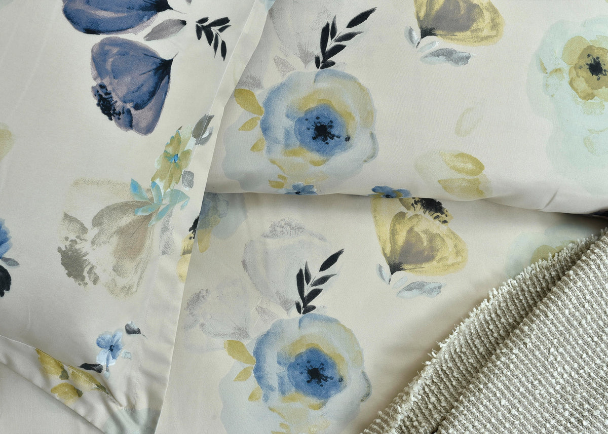 Cotton quilt cover close-up: pale background with blue flowers, yellow accents, and textured border