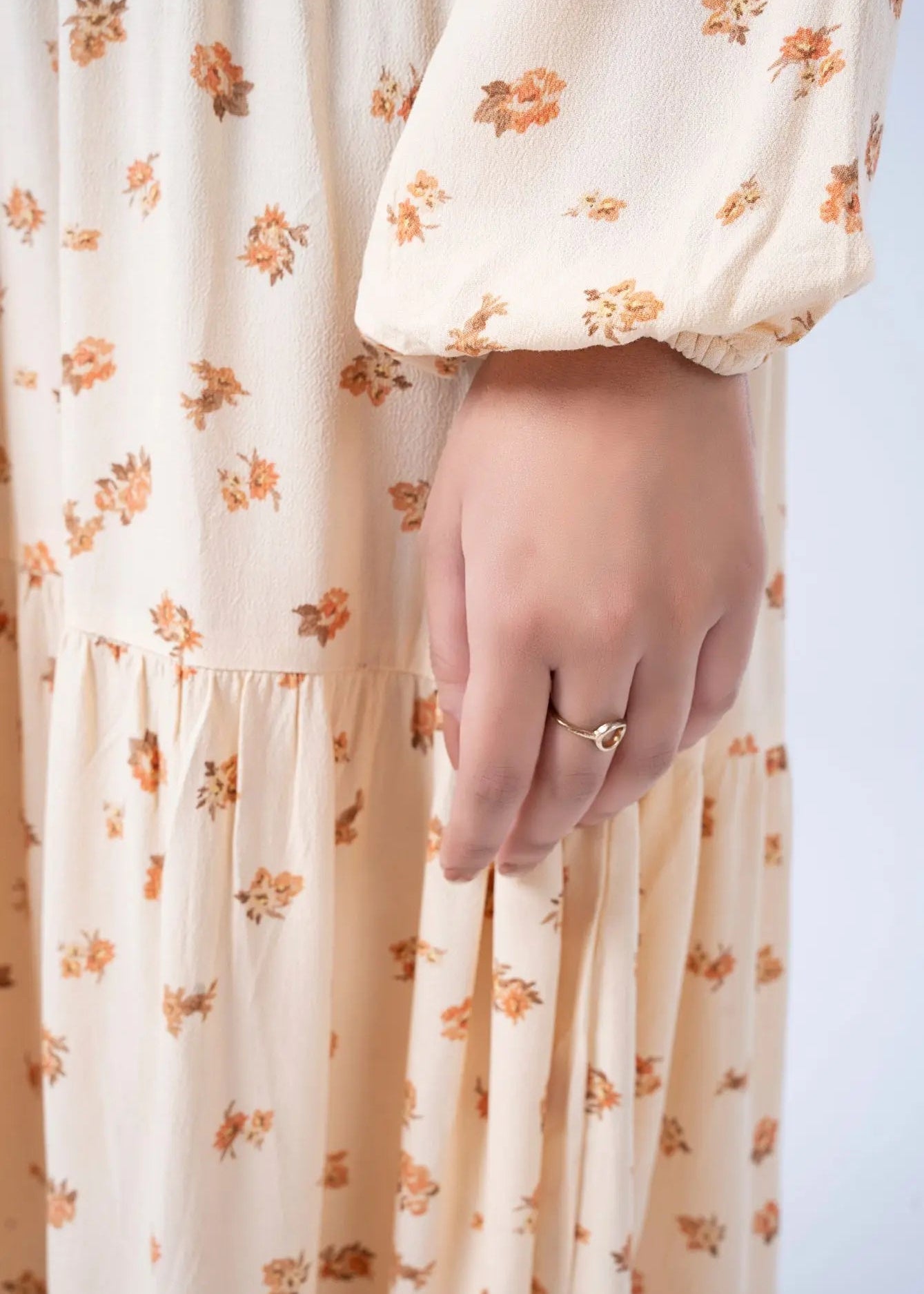 Women's long dress in light beige with floral print, elastic cuffs, and gathered waist