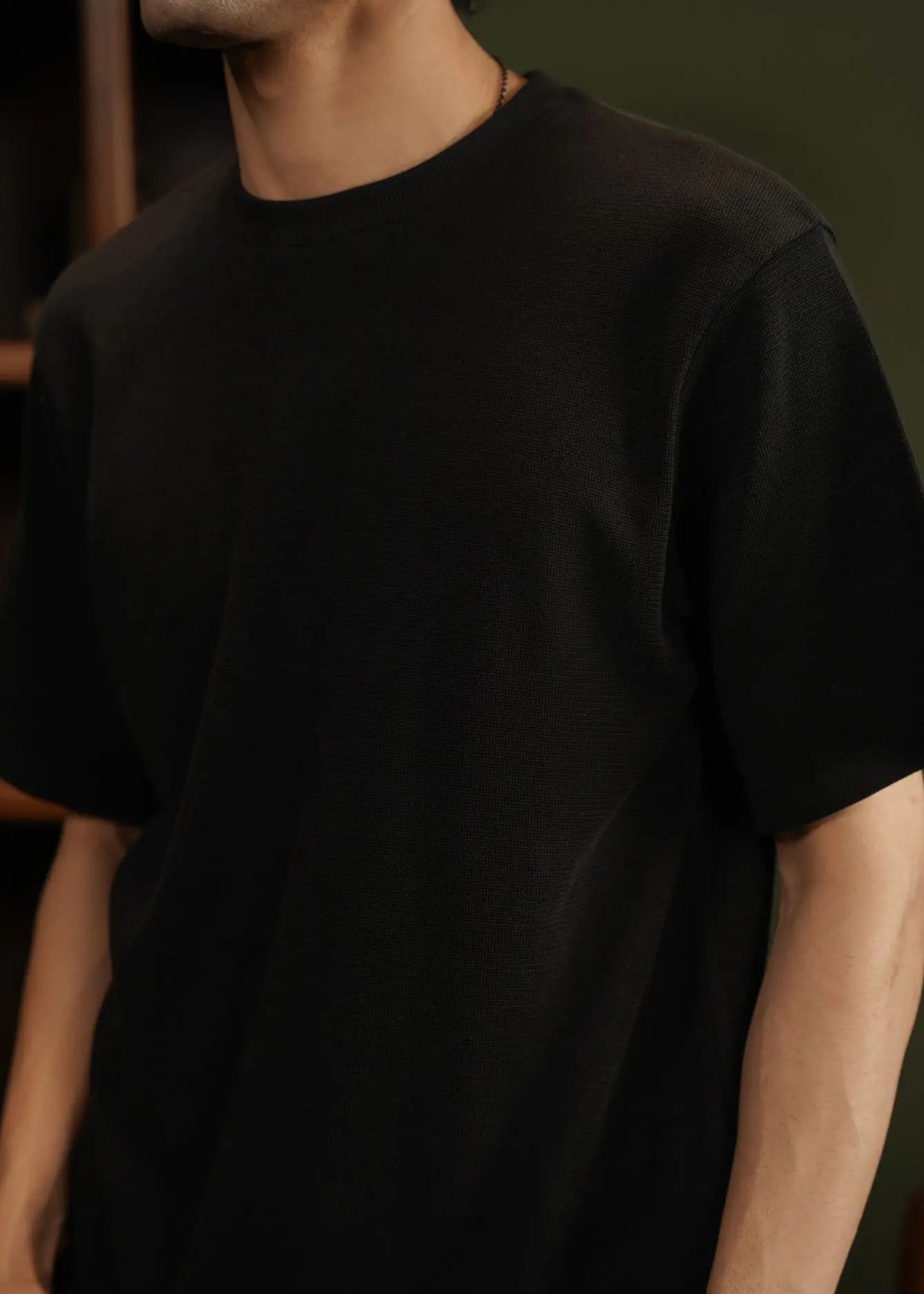 Black waffle-knit T-shirt close-up: crew neckline and short sleeves