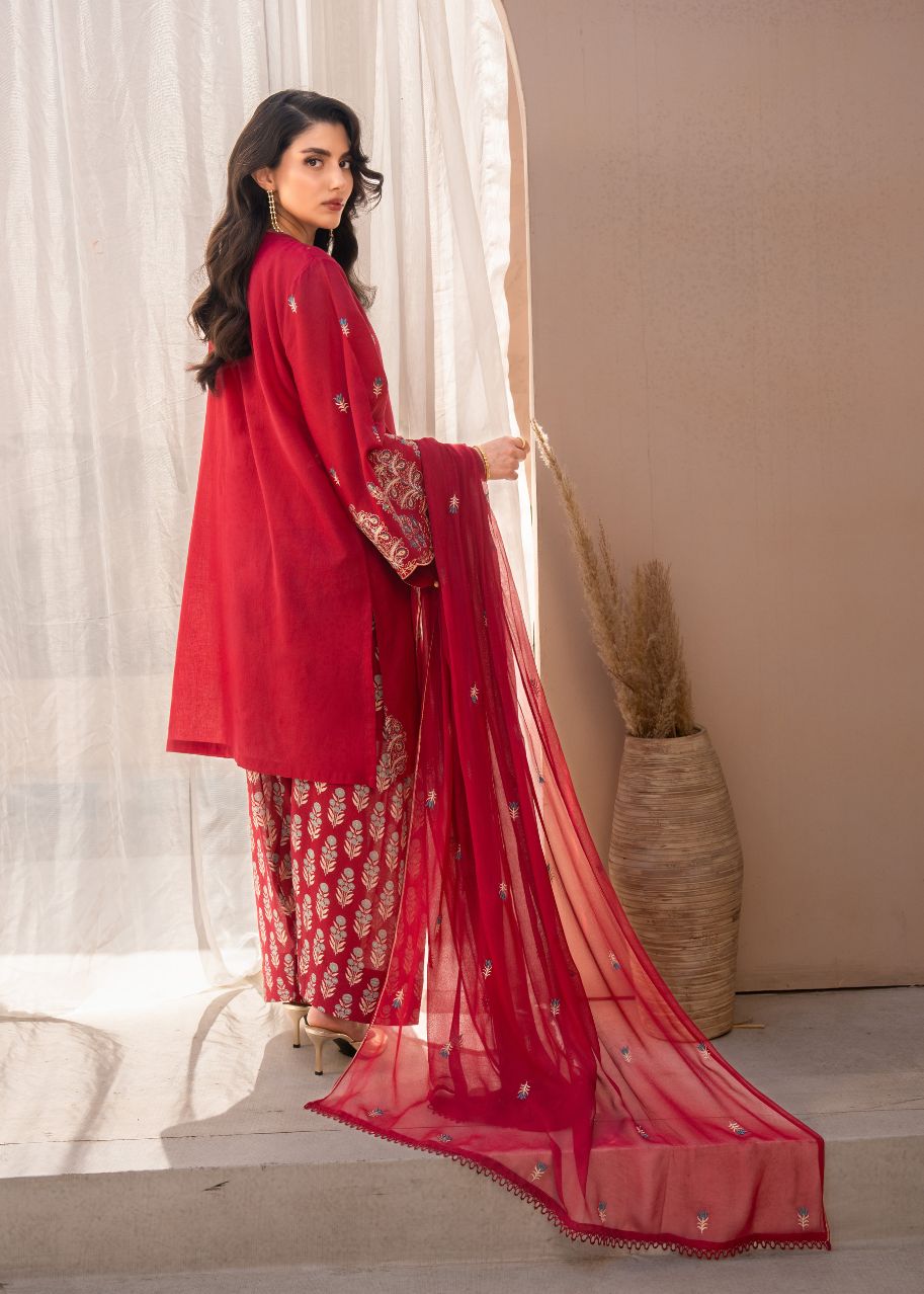 Women's maroon embroidered kurta and pants with trailing sheer dupatta, side pose