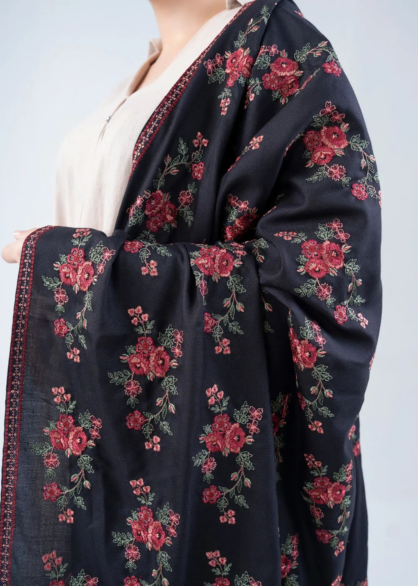 Black wool winter shawl draped detail with red floral pattern and cream border