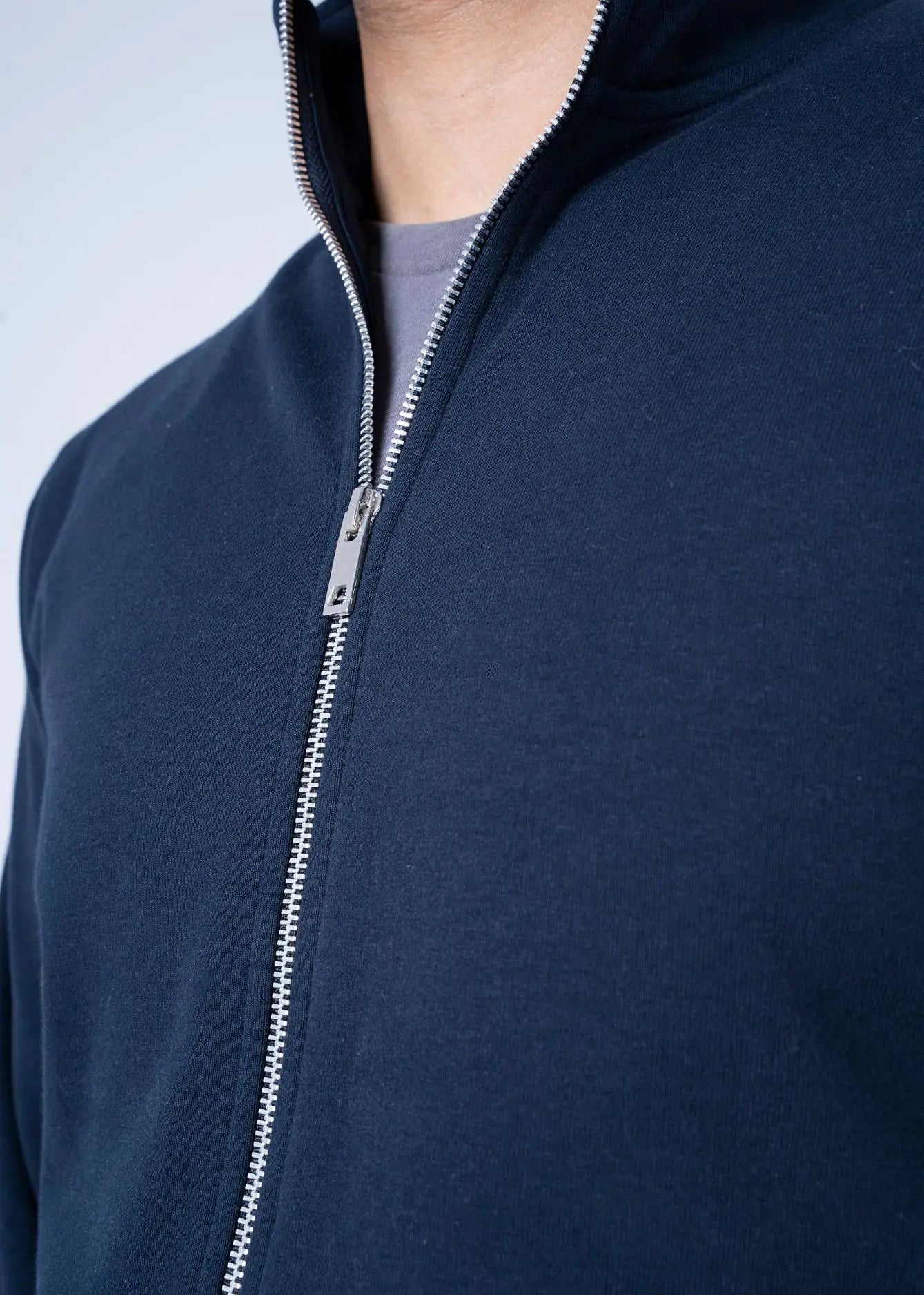 Navy fleece zip-up hoodie with metal zipper and raised collar edge