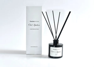 Black reed diffuser with dark reeds and white boxed packaging