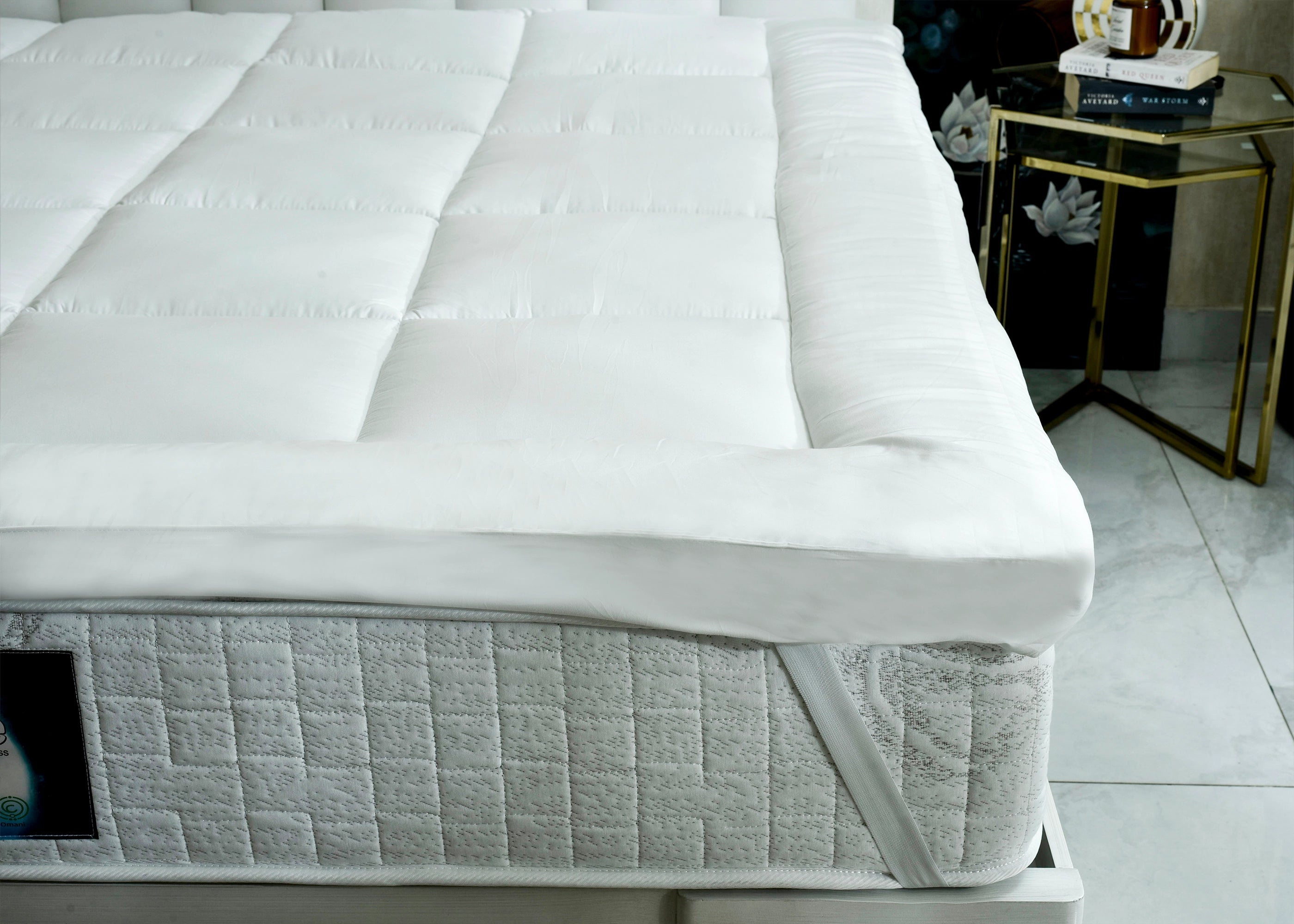 White quilted mattress corner with stitched channels and gray side panel
