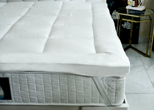 White quilted mattress corner with stitched channels and gray side panel