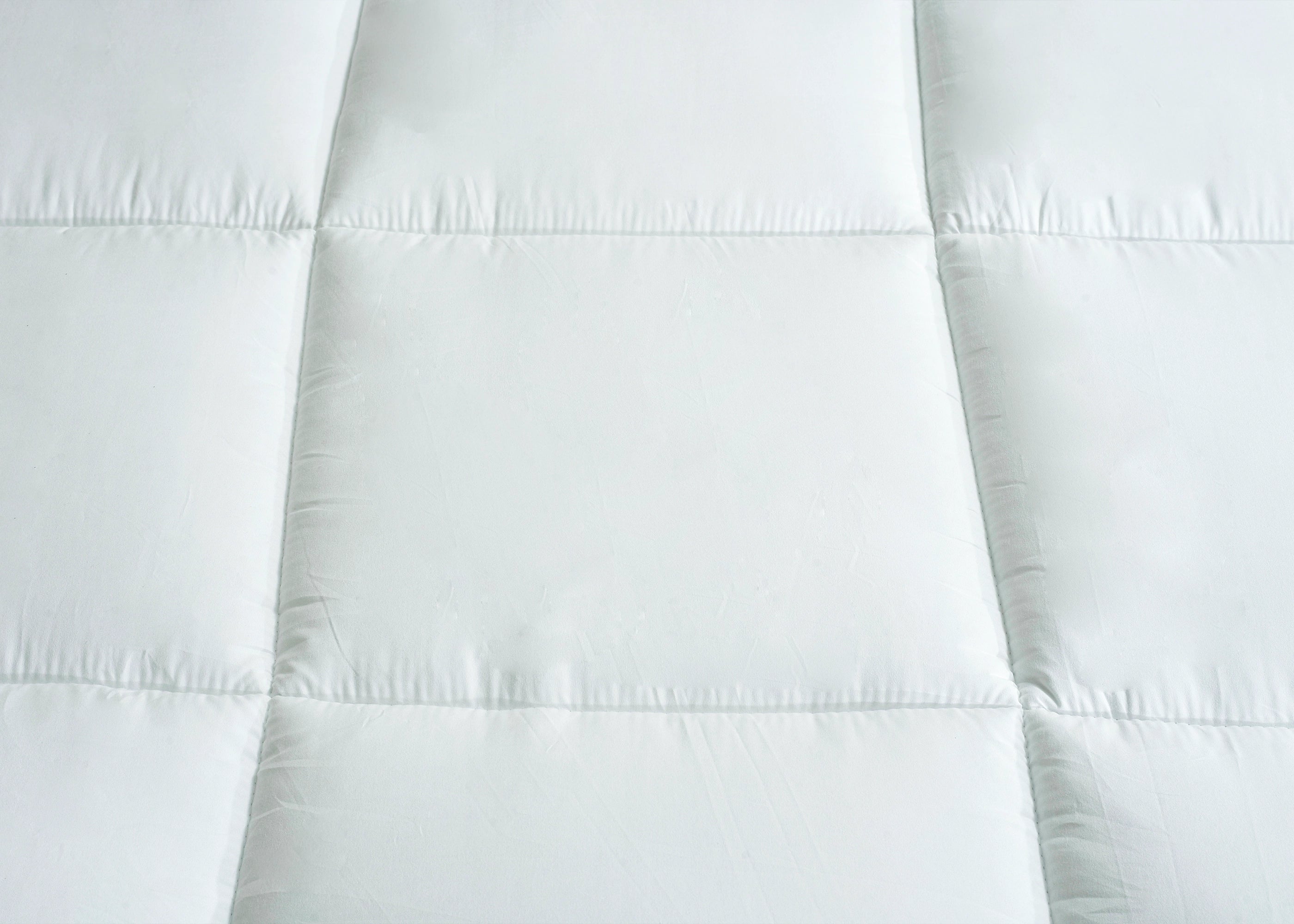 White quilted mattress top with stitched channel rows and padded sections