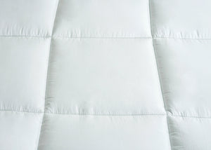 White quilted mattress top with stitched channel rows and padded sections
