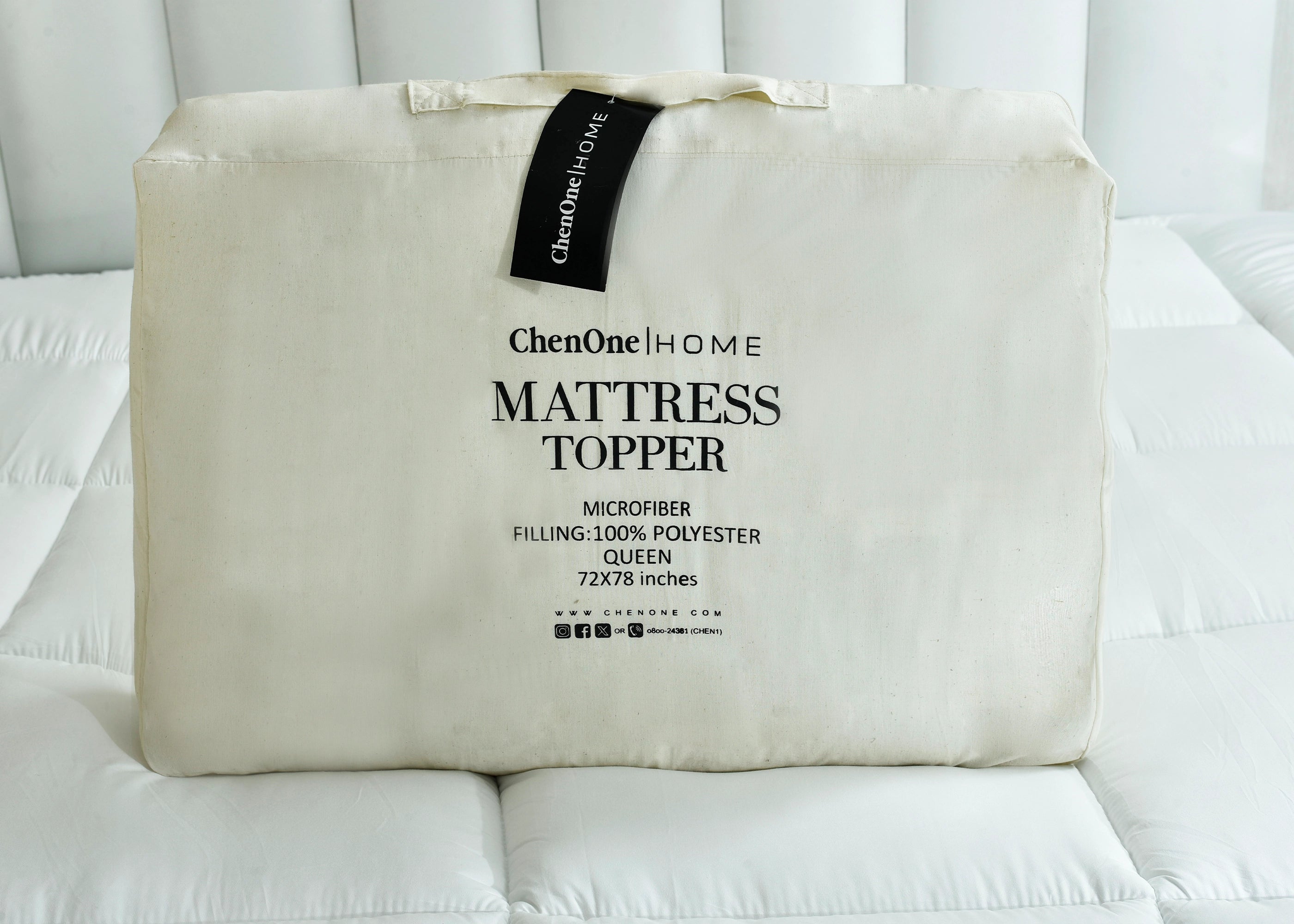 Beige mattress topper cover with hanging label and 'Mattress Topper' text