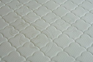 White quilted mattress surface with raised fan and swirl stitching pattern