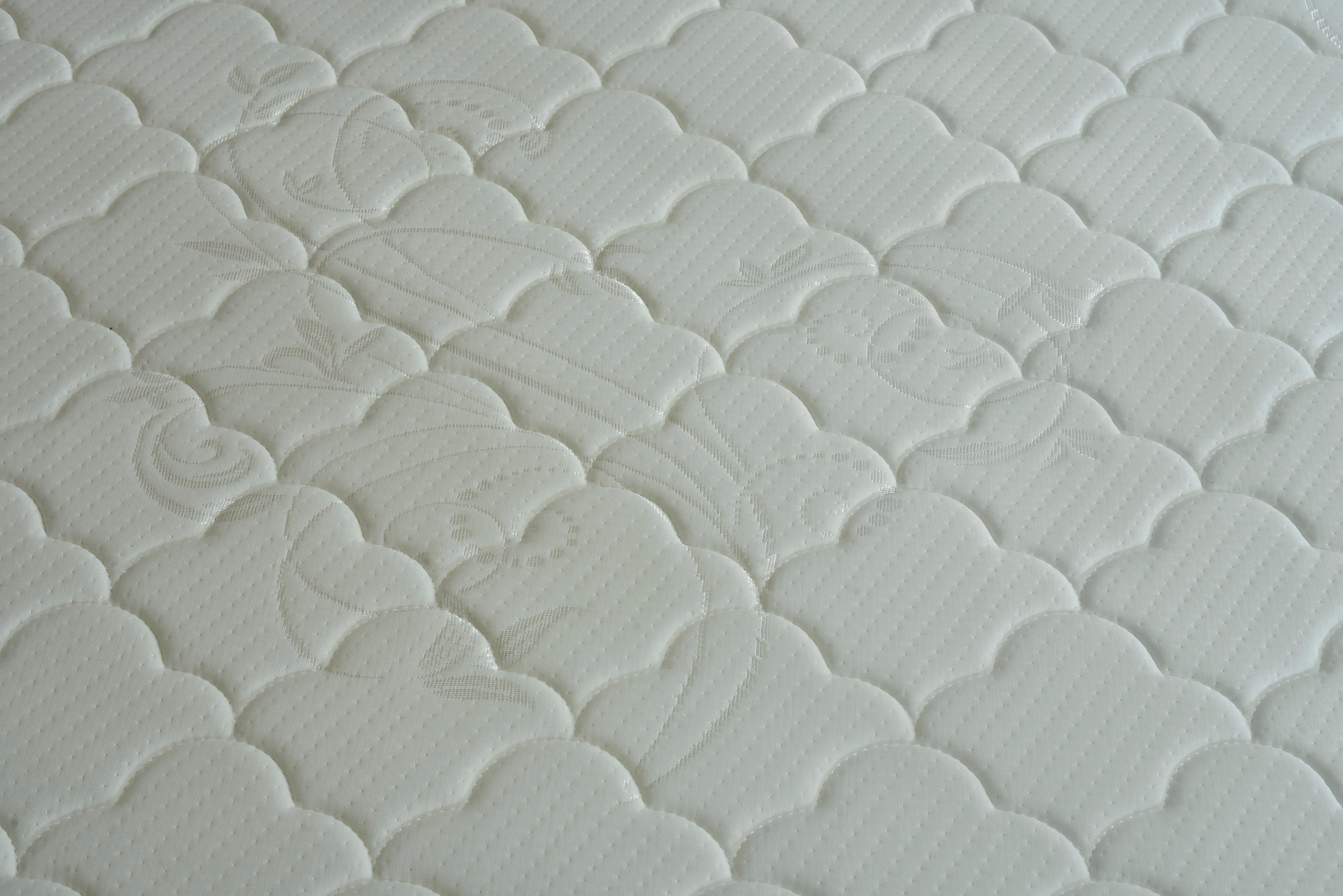 White quilted mattress surface with raised fan and swirl stitching pattern