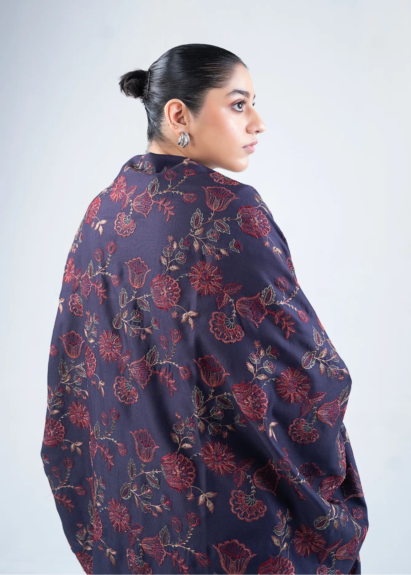 Women's wool winter shawl in dark navy with burgundy floral pattern, draped back view