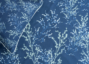 Navy cotton bed sheet with white tree branch pattern, corner view