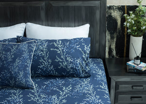 Navy cotton bed sheet with white tree branch pattern, close bed angle