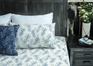 White cotton bed sheet with blue botanical branch pattern; two coordinating pillow shams