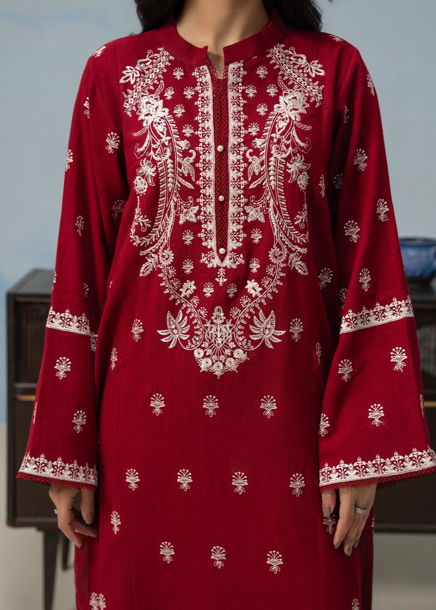 Close-up of maroon embroidered kurta neckline and button placket with sleeve borders