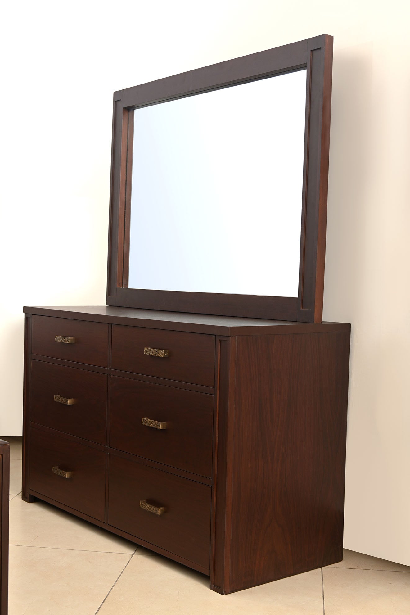 Dark wood dresser with large mirror and four drawers with brass handles