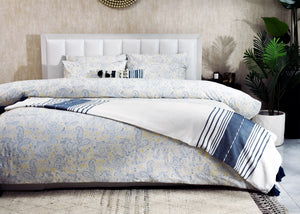Duvet cover set on bed with blue paisley print, white panels, and navy stripes