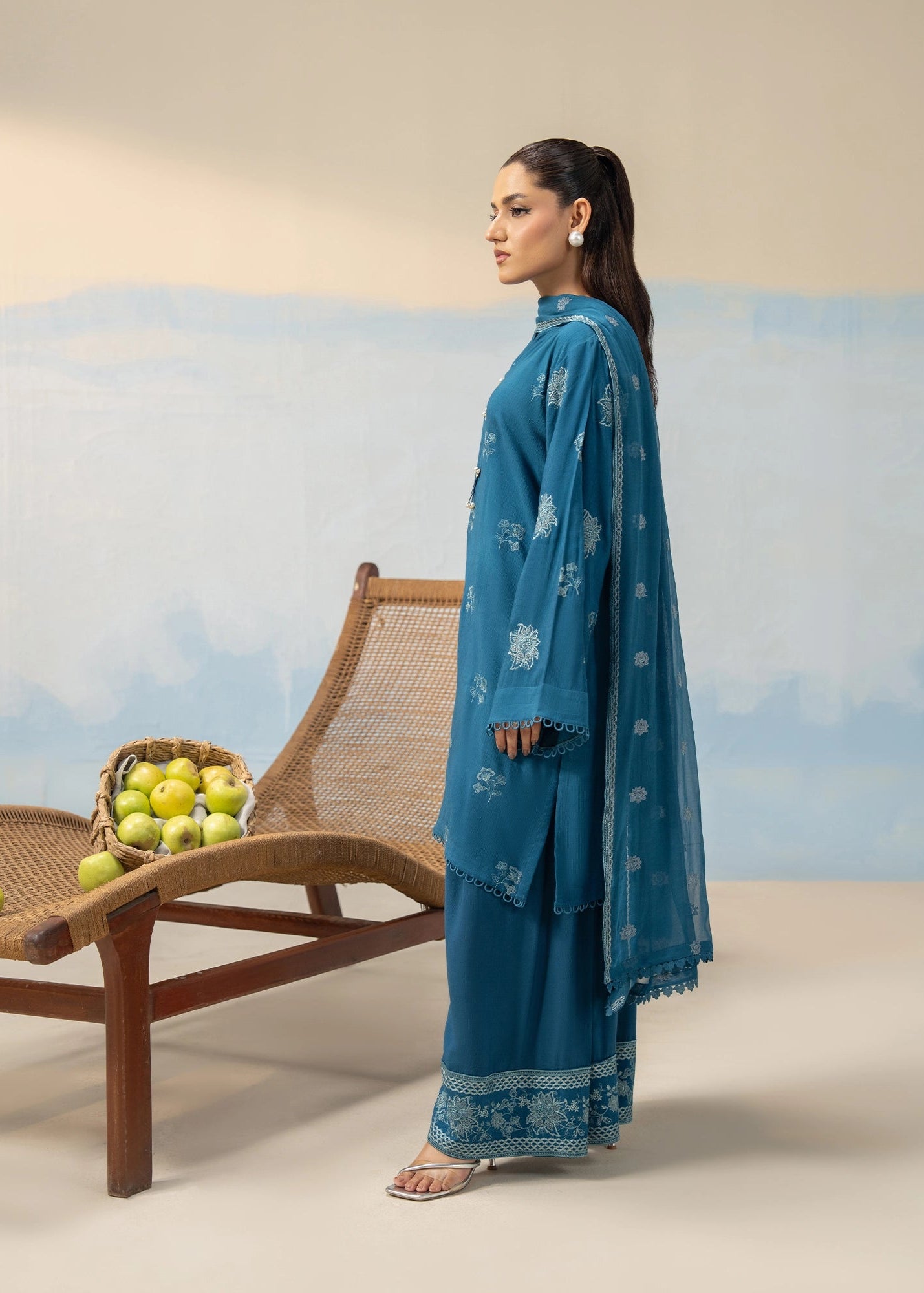 Women's blue embroidered 3-piece suit shown in profile with long kurta and wide-leg pants
