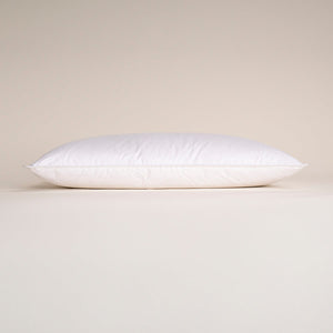 White soft-filled pillow lying horizontally with smooth fabric cover